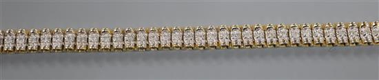 A modern 14k yellow metal and diamond set line bracelet, 18cm.